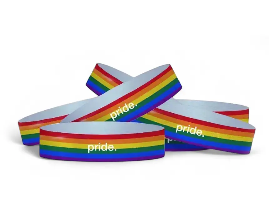 un grupo de pulseras de Tyvek personalizadas con los colores del orgullo, con la palabra pride escrita sobre ellas